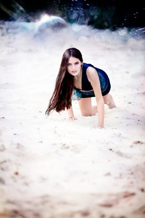 Sexual brunette woman in dark blue dress on cosmic beachの写真素材