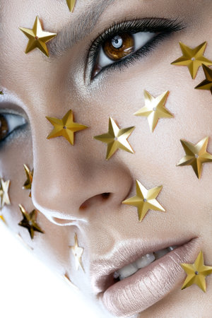 Close up portrait of a pretty woman with stars on face on a white backgroundの写真素材