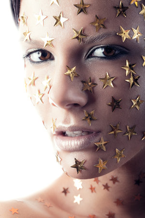 Close up portrait of a pretty woman with stars on face on a white backgroundの写真素材