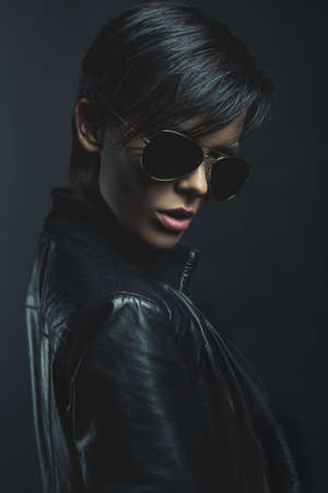 Portrait of stylish woman on a dark blue backgroundの写真素材