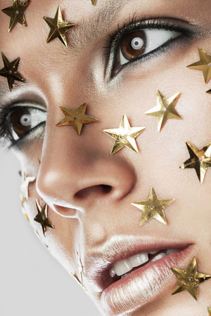woman with gold stars on faceの写真素材