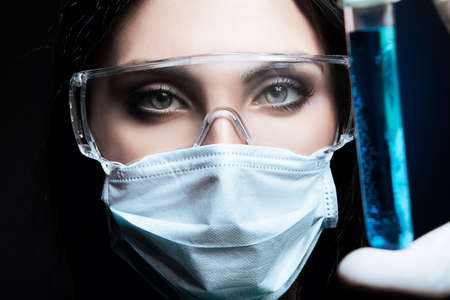 scientist and tube with liquid in darkの写真素材