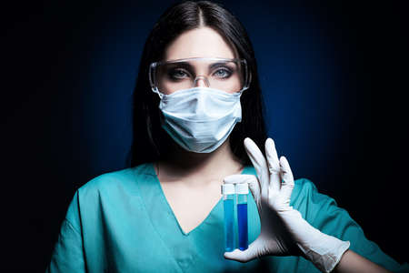 scientist holding tubes in darkの写真素材