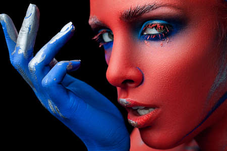 Red face and blue hand close-upの写真素材