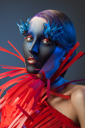 Portrait of woman with a frightening makeup on nlue background