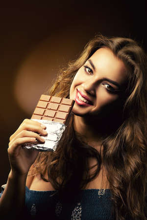 smiling woman with big chocolate barの写真素材