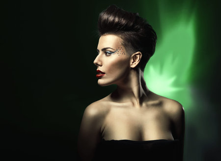 woman with red lips in black dress in dark green lightの写真素材