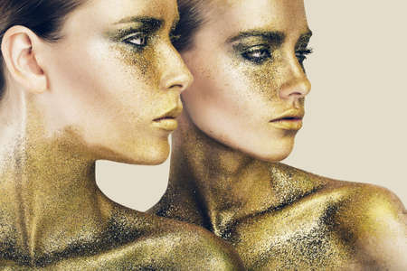 two women in gold glittersの写真素材