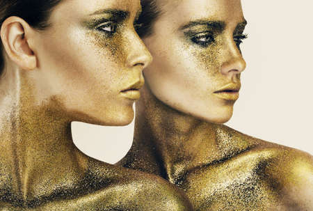 two women in gold glittersの写真素材