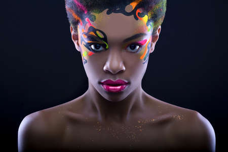 Arfican girl with creative neon make up on black backgroundの写真素材