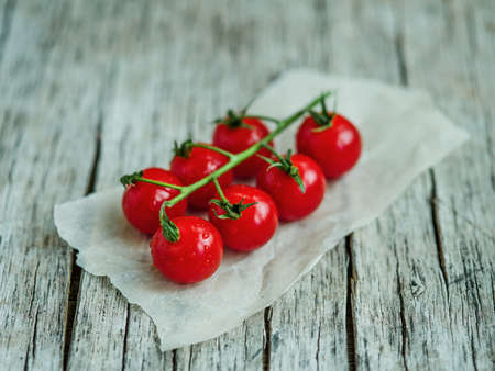 Bunch of fresh tomatoes and tomato juice in glass on wooden tableの写真素材