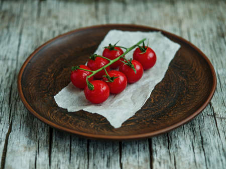Bunch of fresh tomatoes and tomato juice in glass on wooden tableの写真素材