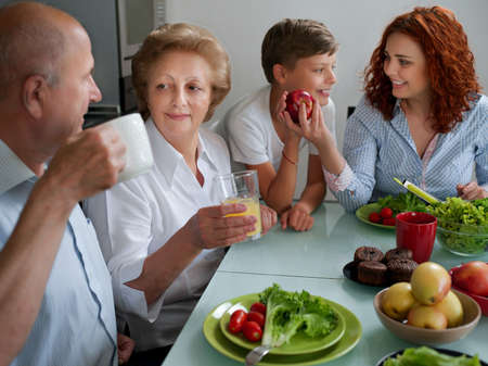 mature woman with family dinner at table, home, parents, children and grandparents, happy smile lunchの写真素材