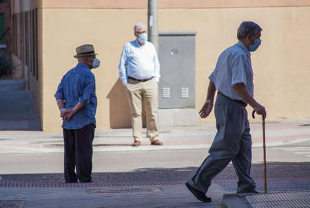 Madrid / Spain - 06/18/2020: Group of old men in the street. New situation in Spain about the pandemic of Covid-19. People are using mask in their new life routine.のeditorial素材