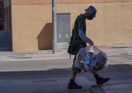 Madrid / Spain - 06/18/2020: Man on the street with garbage. New situation in Spain about the pandemic of Covid-19. People are using mask in their new life routine.のeditorial素材