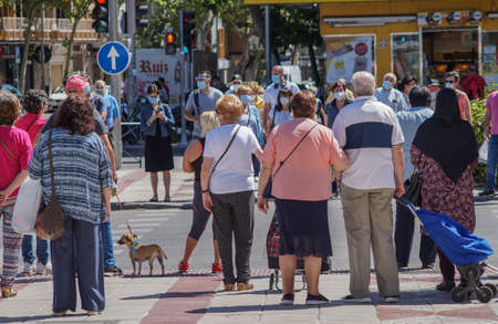 Madrid / Spain - 06/18/2020: Large group of people on the street. New situation in Spain about the pandemic of Covid-19. People are using mask in their new life routine.のeditorial素材