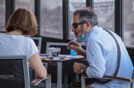 Madrid / Spain - 07 13 20: Couple on a terrace doing a bad use of a face mask during the pandemic of...