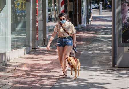 Madrid / Spain - 07 13 20: young girl outside in the summer with face mask and a dogのeditorial素材