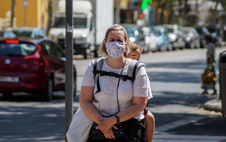 Madrid / Spain - 07 13 20: Woman on the street carrying her baby and wearing a beautiful face maskのeditorial素材