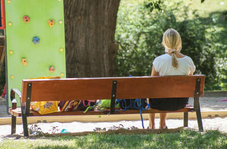 Madrid / Spain - 07 23 20: Woman sitting on a bench in Retiro park in summer during the Covid-19 pandemicのeditorial素材
