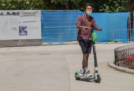 Madrid / Spain - 07 23 20: tourist using a scooter at Retiro park and wearing face maskのeditorial素材