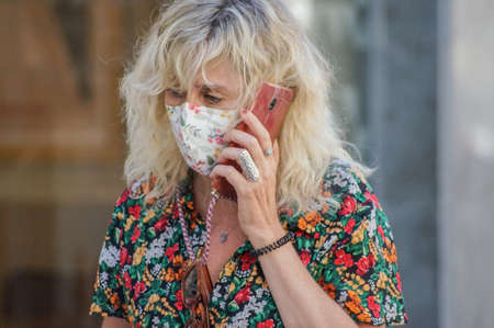 Madrid, Spain / 08 19 20: Coronavirus crisis in Madrid. Woman speaking by her mobile phone on the street.のeditorial素材