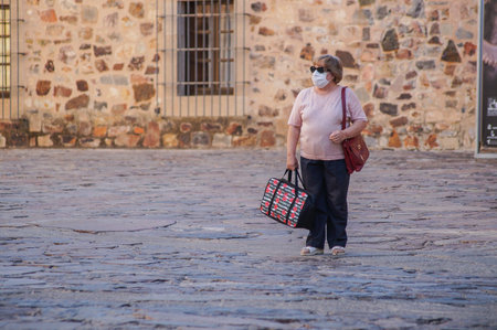 Caceres, Extremadura / Spain - 08 22 2020: woman alone on the street wearing face mask