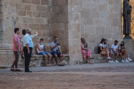 Caceres, Extremadura / Spain - 08 22 2020: people sitting outside in a summer day next to a medieval building during the pandemicのeditorial素材