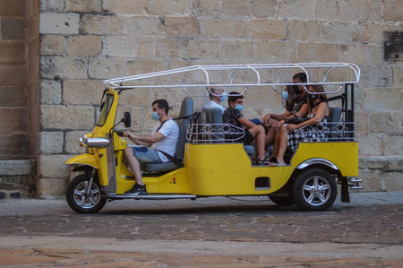 Caceres, Extremadura / Spain - 08 22 2020: tourist doing a trip in tuk tuk vehicleのeditorial素材