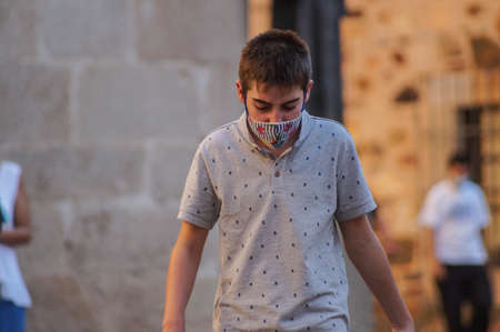 Caceres, Extremadura / Spain - 08 22 2020: A young boy walking on the street and wearing face maskのeditorial素材