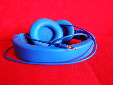 blue headphone folded in red background