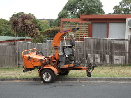 a wood chipper machinery parked on the side of a road