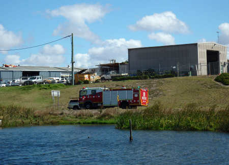 Fire Truck on the move responding to an incident passing by a wetland lake