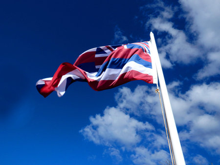 Waving Hawaiian flag on blue sky sunny day in Hawaii