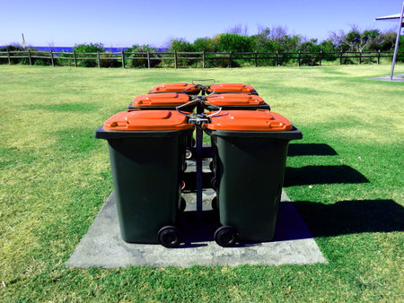 half dozen of wheelie bins on a parkの写真素材