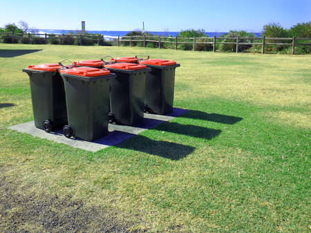 half dozen of wheelie bins on a parkの写真素材
