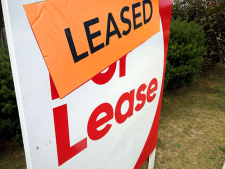House for lease sign in front of a home with the leased stickerの写真素材