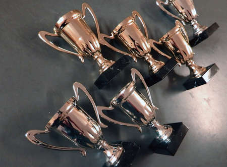 Collection of golde trophy cups in gray backgroundの写真素材