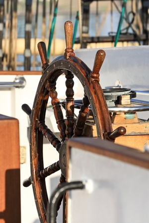 Old helm on a sailing ship in sunrise lightの写真素材