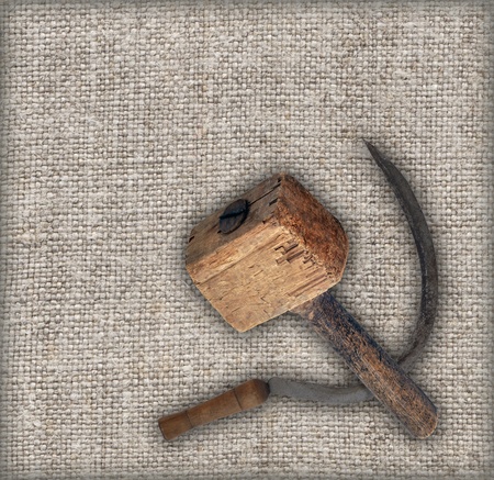 Old tools on canvas: sickle and wooden hammer mallet. Made in the USSR, Russia, Siberia, in the mid-20th centuryの写真素材