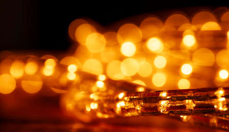 Christmas lights with low depht of focus. Blurry background. Abstract lights. Christmas or New Year. Golden colors.の写真素材
