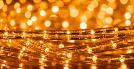 Christmas lights with low depht of focus. Blurry background. Abstract lights. Christmas or New Year. Golden colors.の写真素材