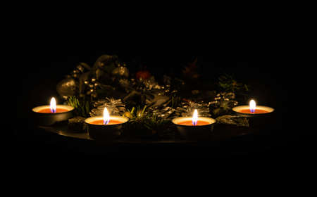 Advent or Christmas wreath to celebrate Christmas and Advent holiday season with burning candles. Close up image. Dark background.の写真素材