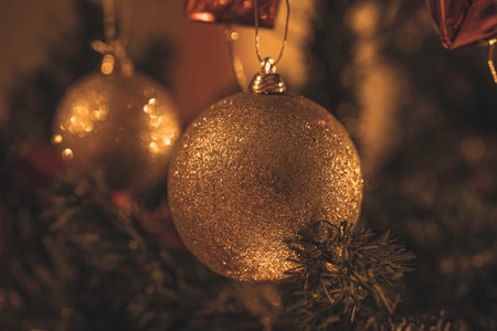 Golden glittering christmas balls. Christmas baubles on christmas tree. Macro photo. Christmas vibe.