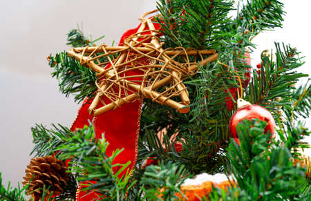 Christmas tree with a golden star made out of wood and christmas decorations. Pine-cone and christmas bauble.の写真素材