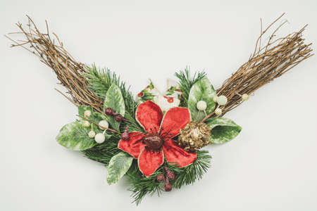 Christmas wreath isolated on white background. Big red flower and green leaves and twigs. Christmas or New Year.の写真素材