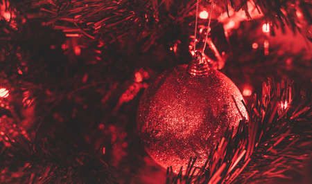 Red glittering christmas balls. Red lights and red festoon. Christmas bauble is a christmas tree. Macro photo. Christmas vibe.の写真素材