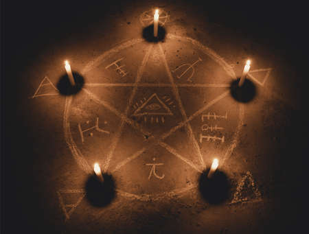 White pentagram symbol on concrete ground. Illuminated with candles. Dark background. Scary, mystical occultismの写真素材