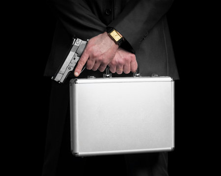 Businessman with gun and silver metal briefcase  Isolated on black の写真素材