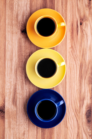 Colorful coffee cups on a wooden background  Top view の写真素材